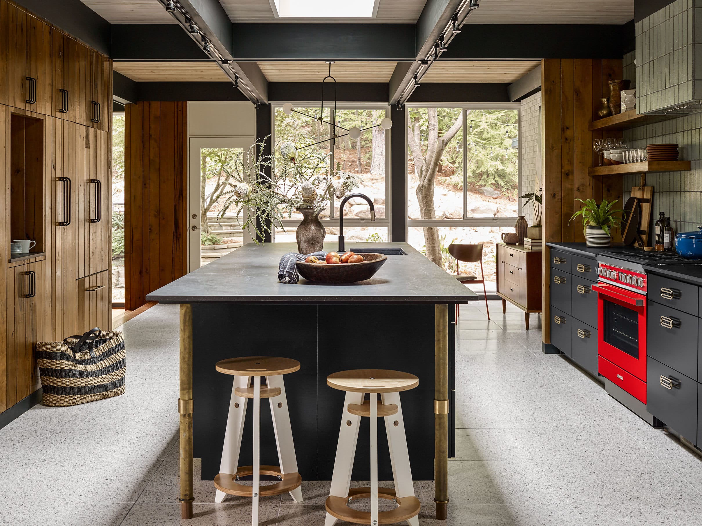 Modern kitchen with natural wood cabinets black drawers and a skylight over the island