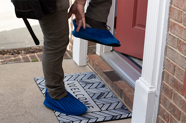 A skylight installer puts on protective booties over his shoes