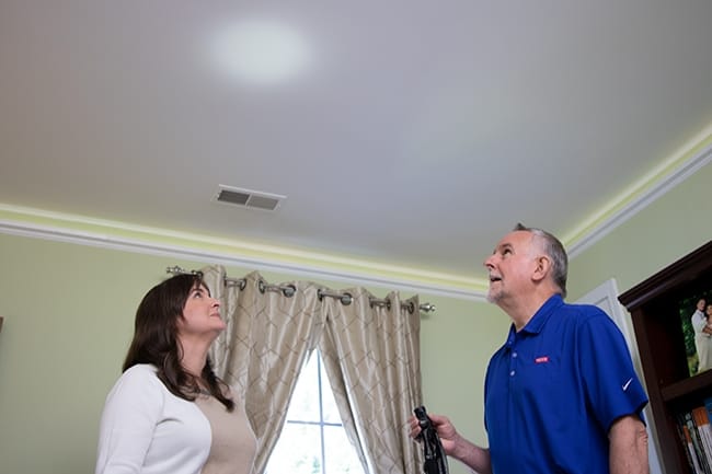 A skylight salesman uses a skylight to show skylight placement