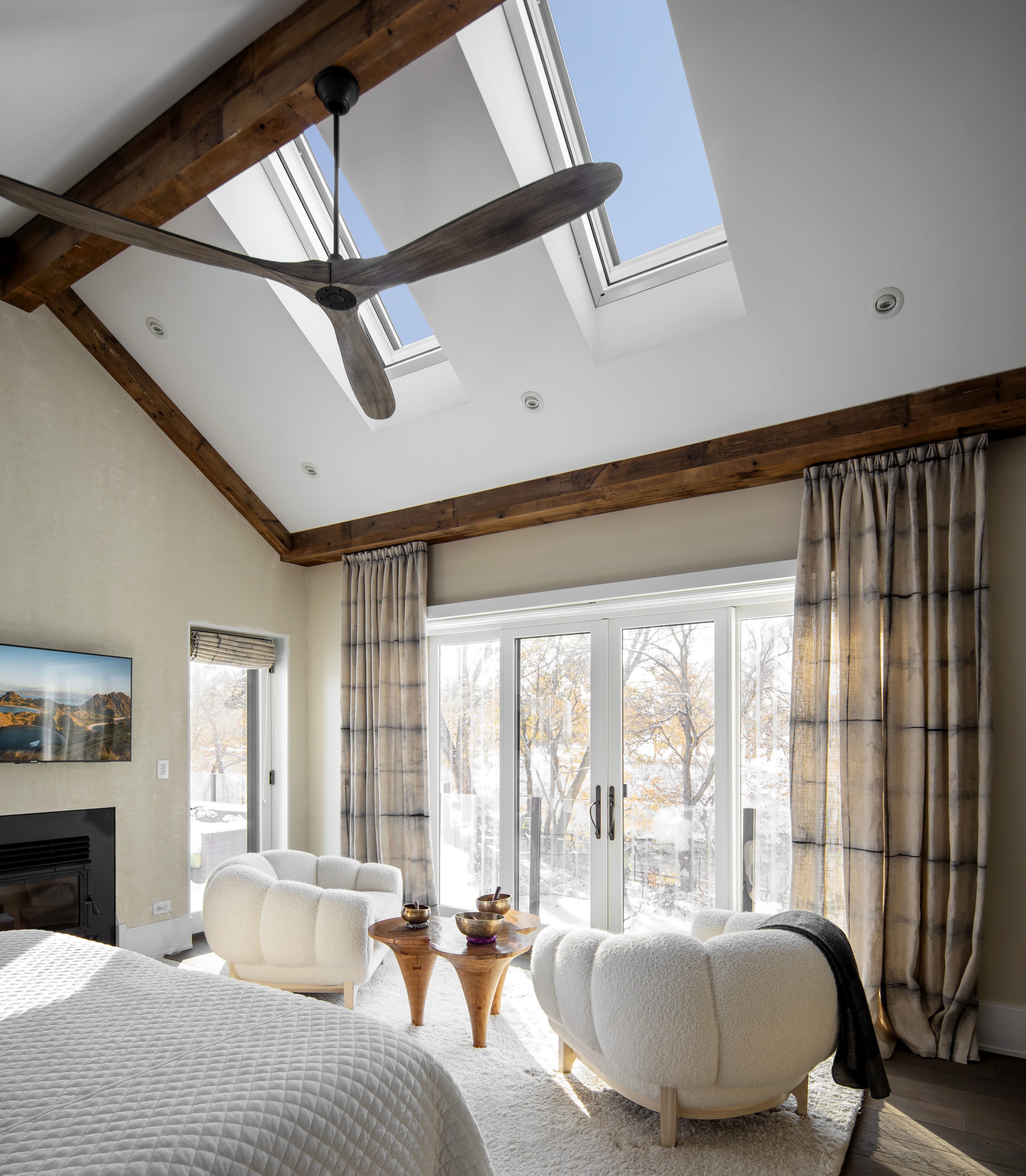 Neutral color master bedroom skylights exposed wooden beams