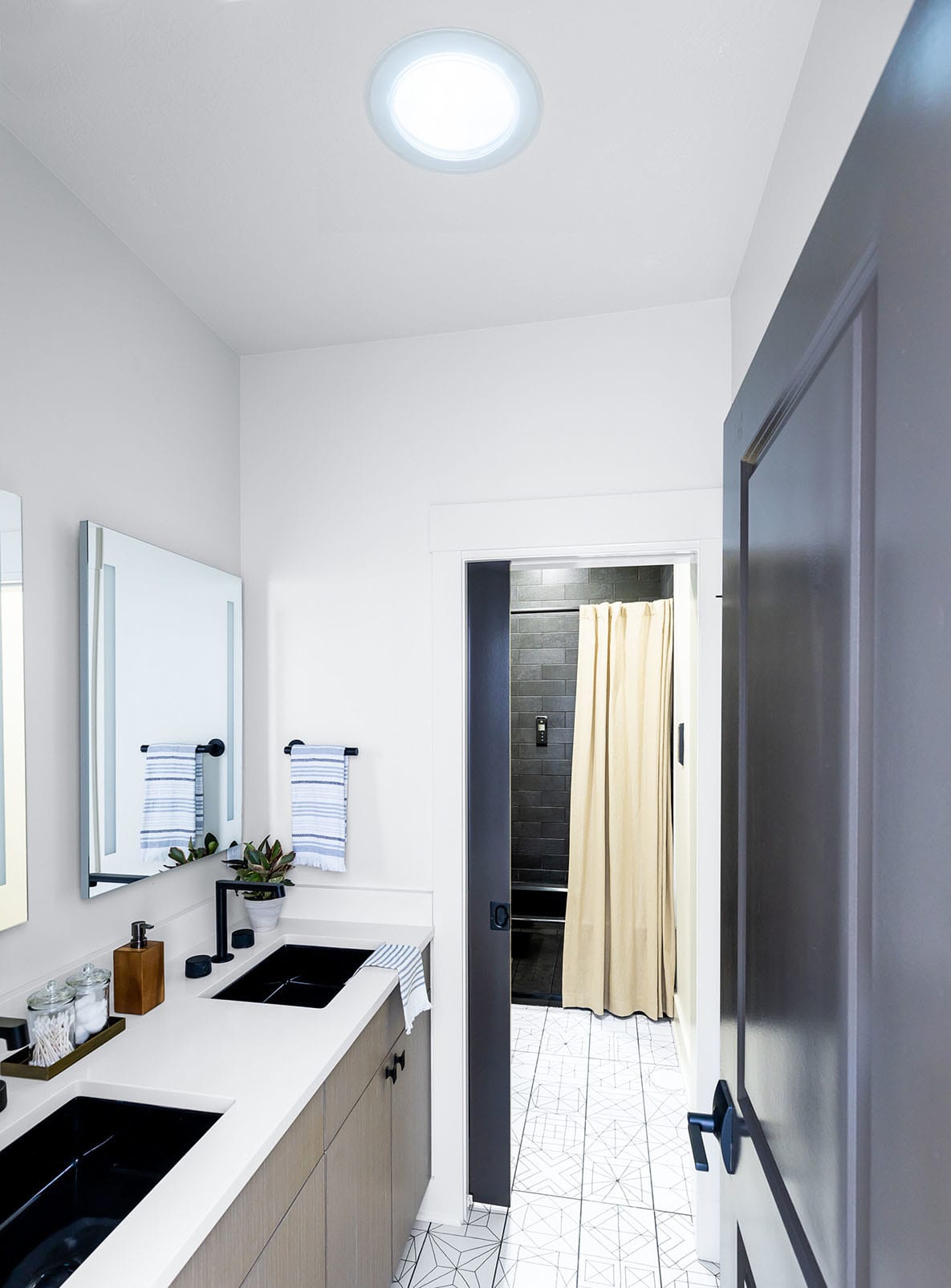 Black and white galley bathroom with Sun Tunnel skylight