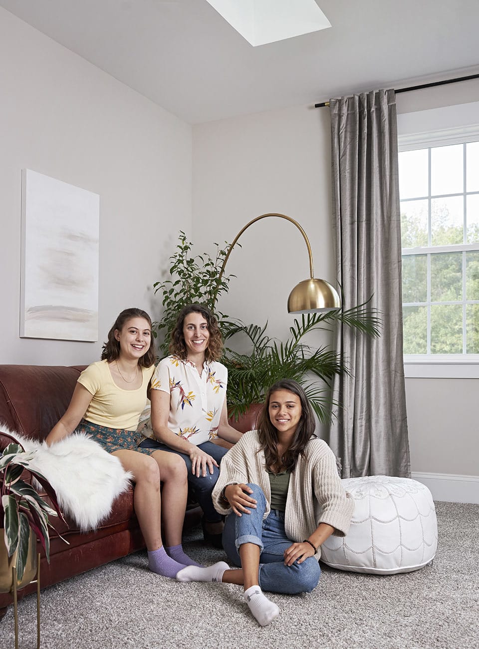 Two skylights brighten a bonus room with a leather couch and plants