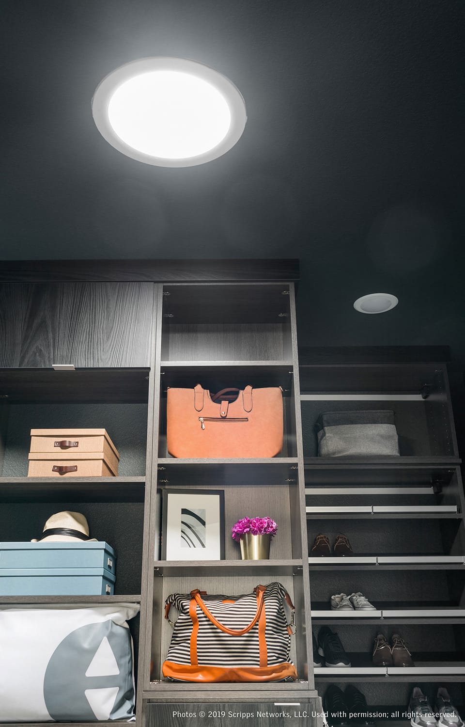 Walk in closet with dark grey walls and natural light from a Sun Tunnel skylight