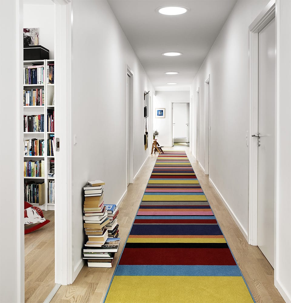 Hallway with colorful striped rug and three Sun Tunnel skylights