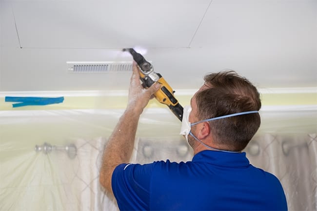 Skylight installer cuts the ceiling hole