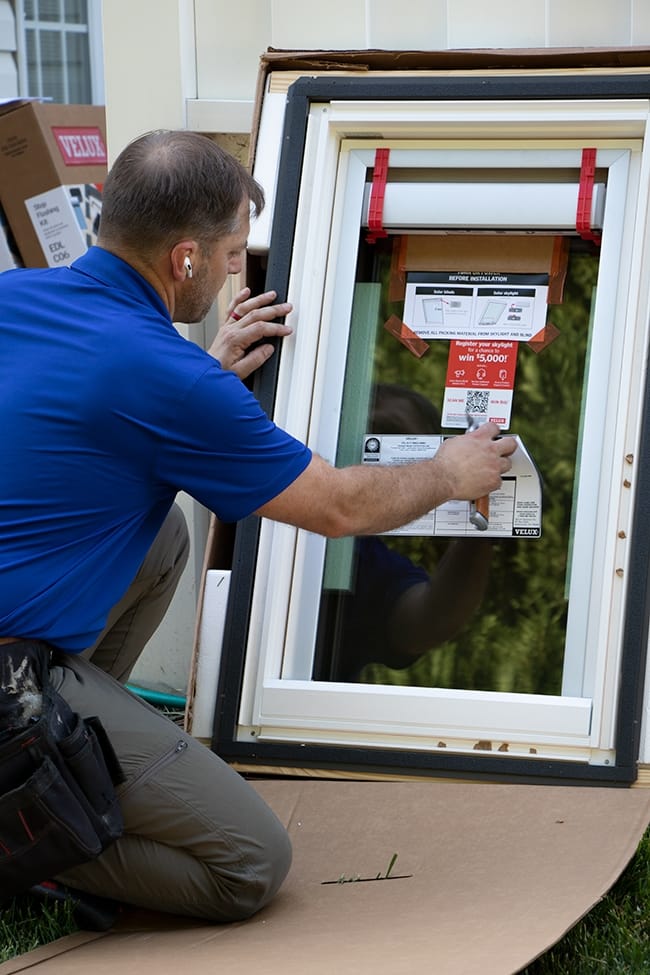 Skylight installer removes product label stickers from a skylight