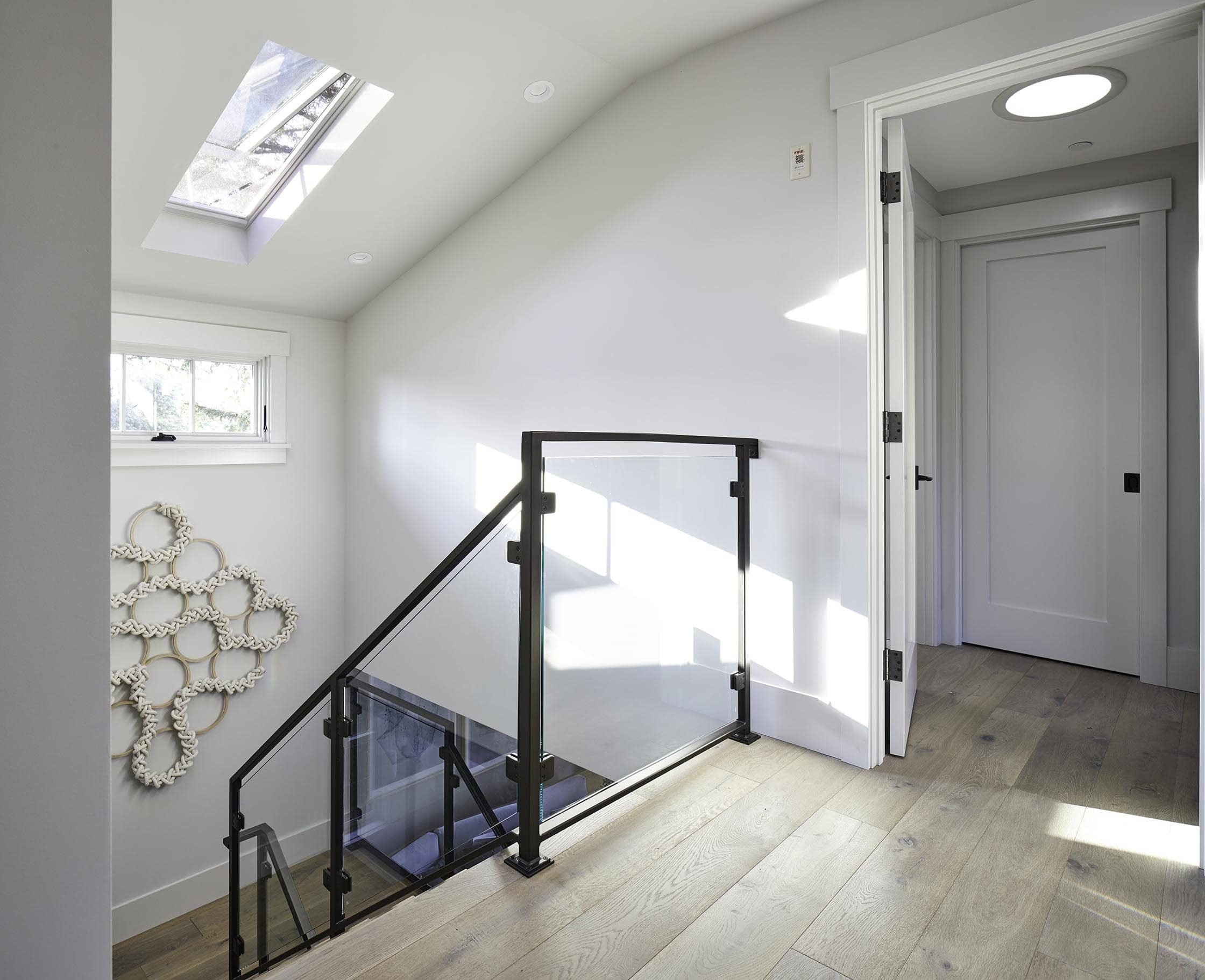 Sunlit stairwell with a skylight and knot art