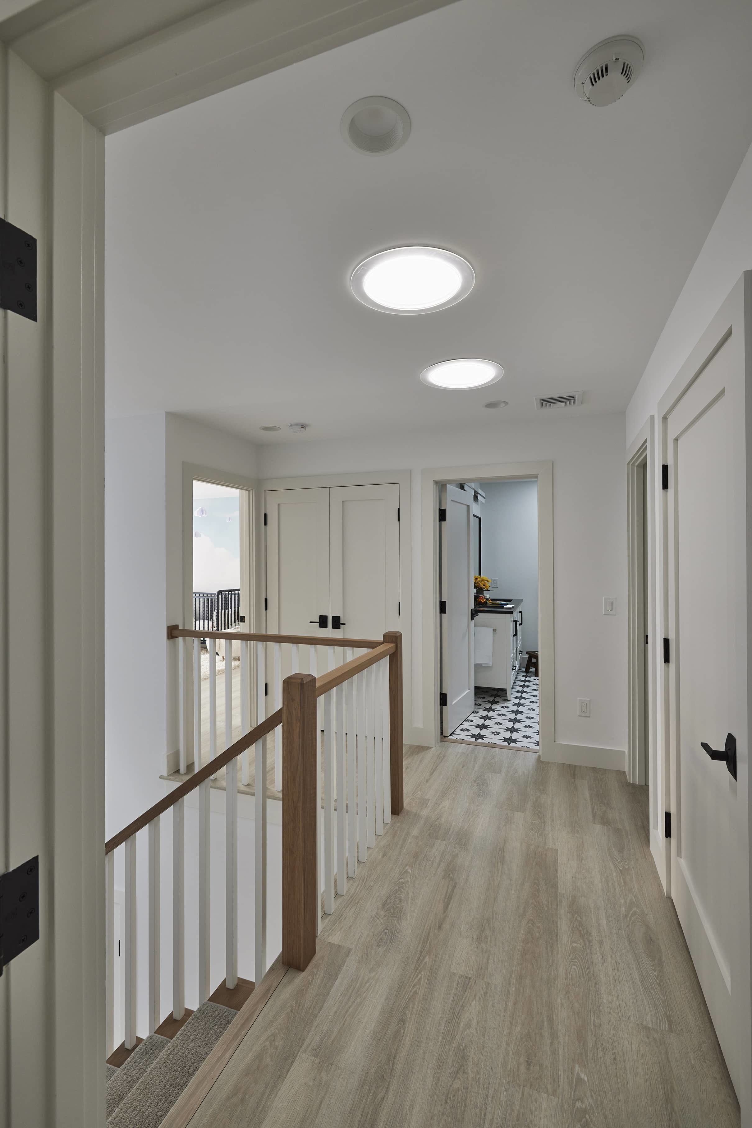 Stairwell landing sun tunnel skylights wood floor