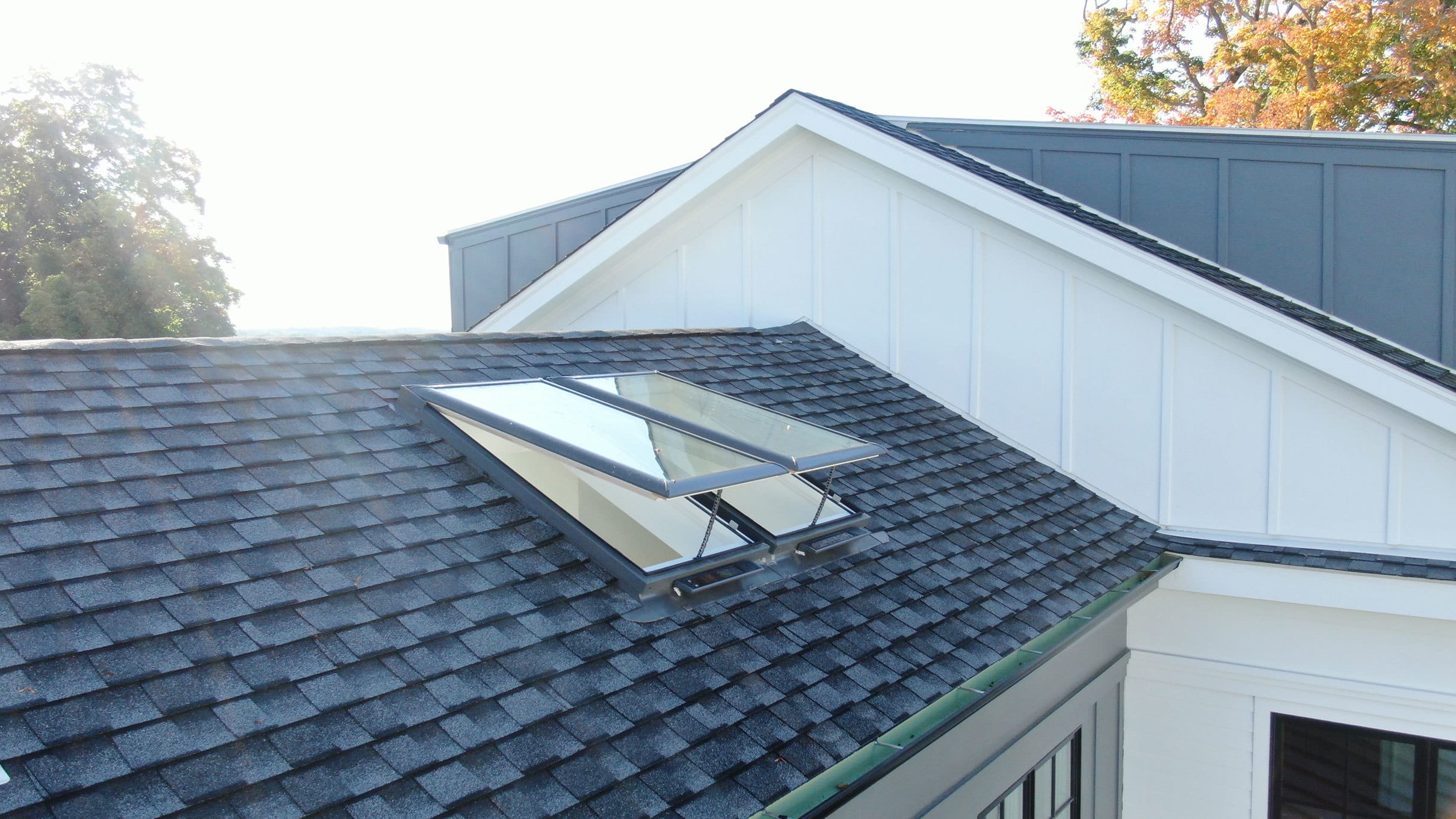 Two open skylights on a shingle roof