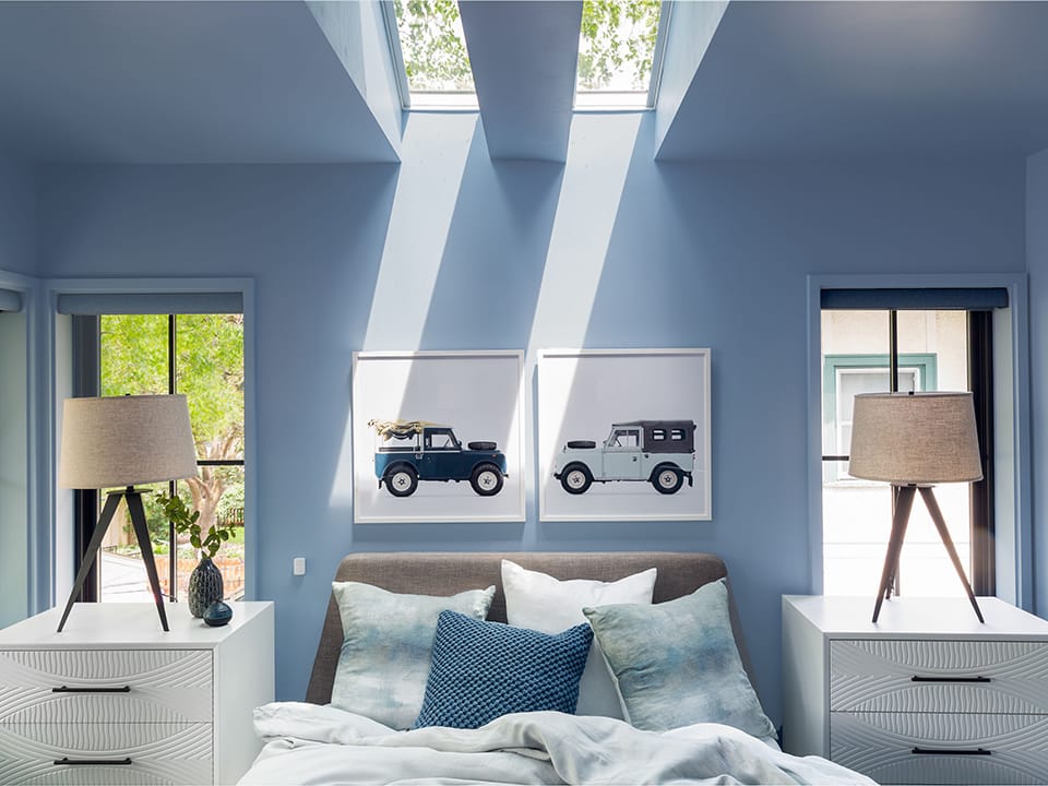 master bedroom with sky blue walls and two skylights