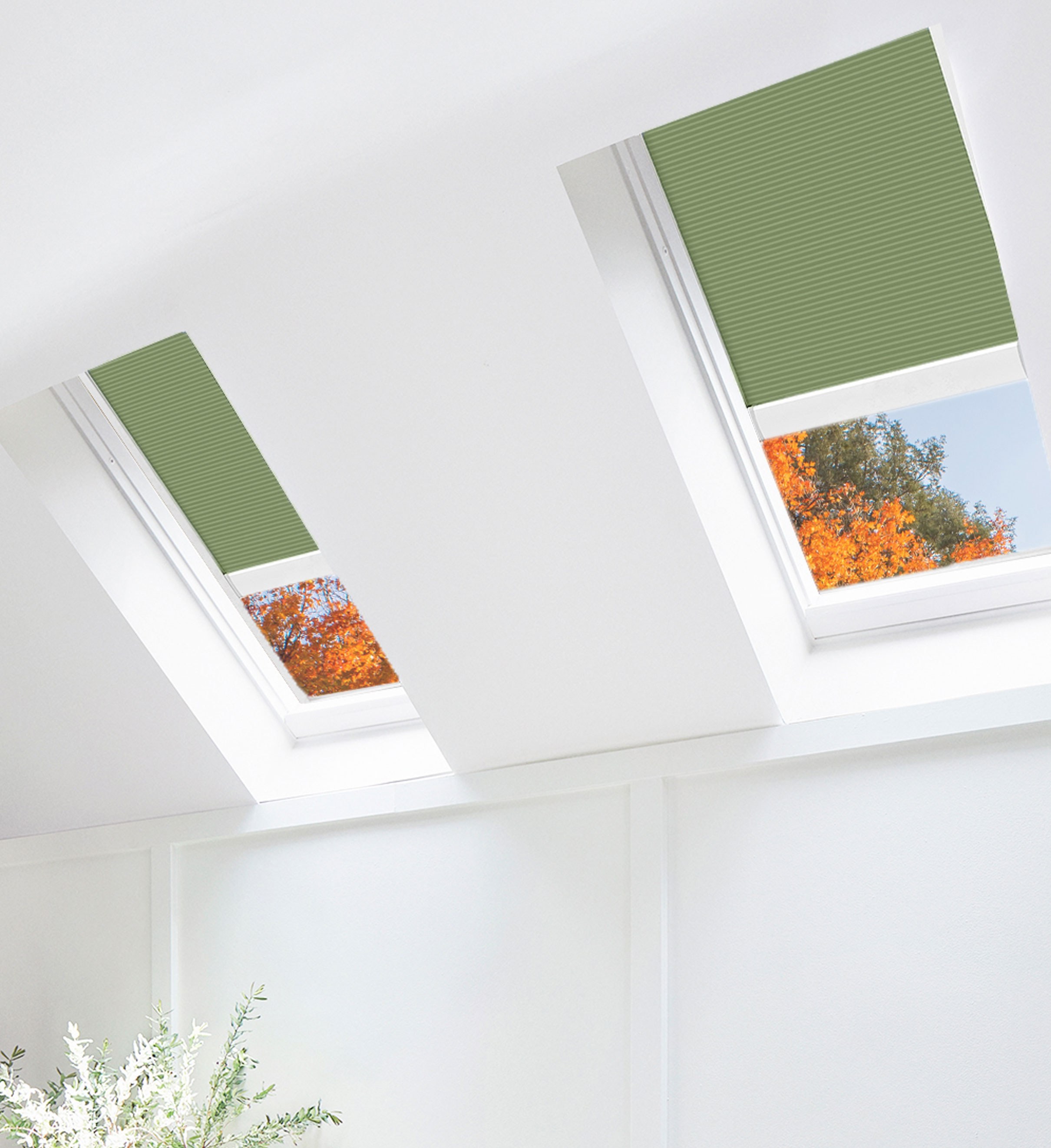 Solar venting skylights with Forest Green solar shades in a bedroom. Fall foliage appears outside through the skylights.
