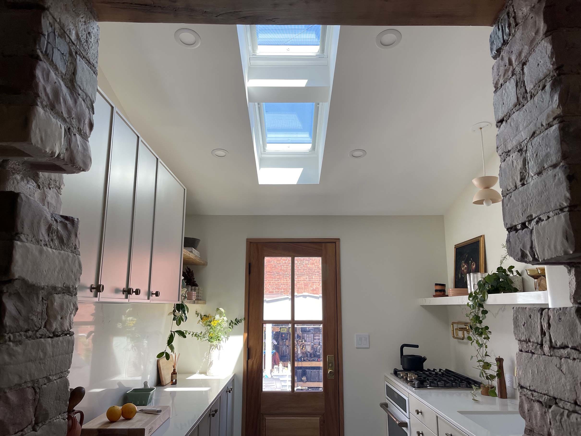Kitchen with skylights gray cabinets and white counters
