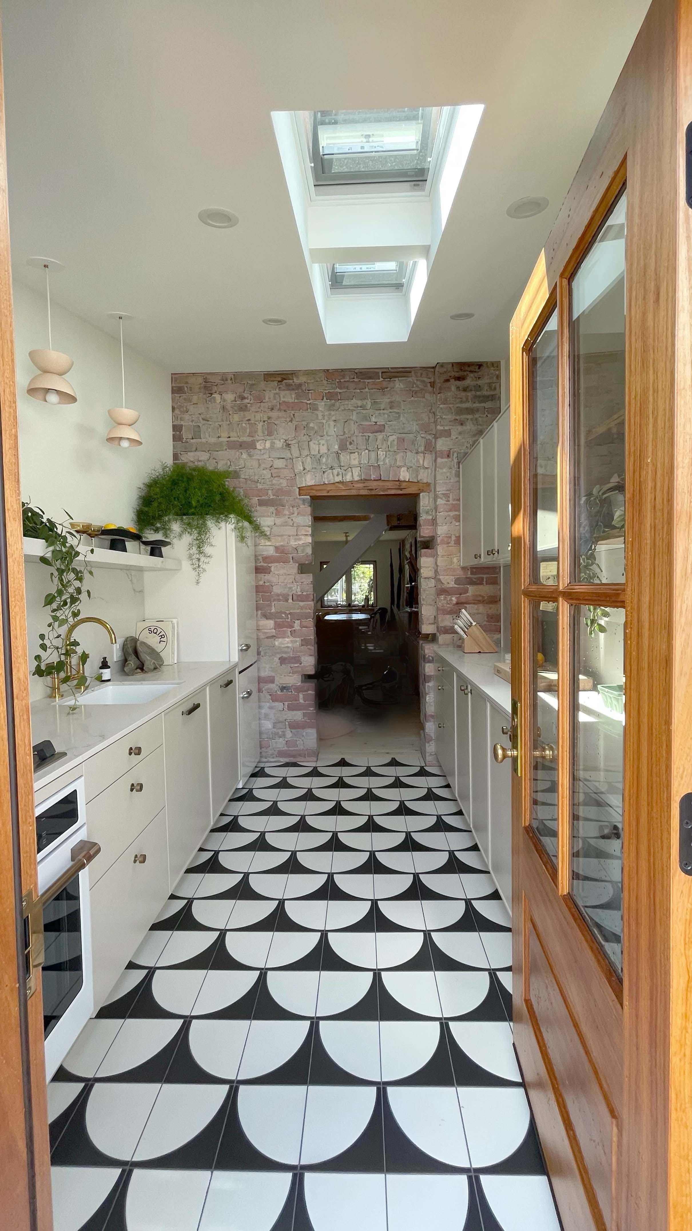 Galley kitchen skylights wood door brick wall