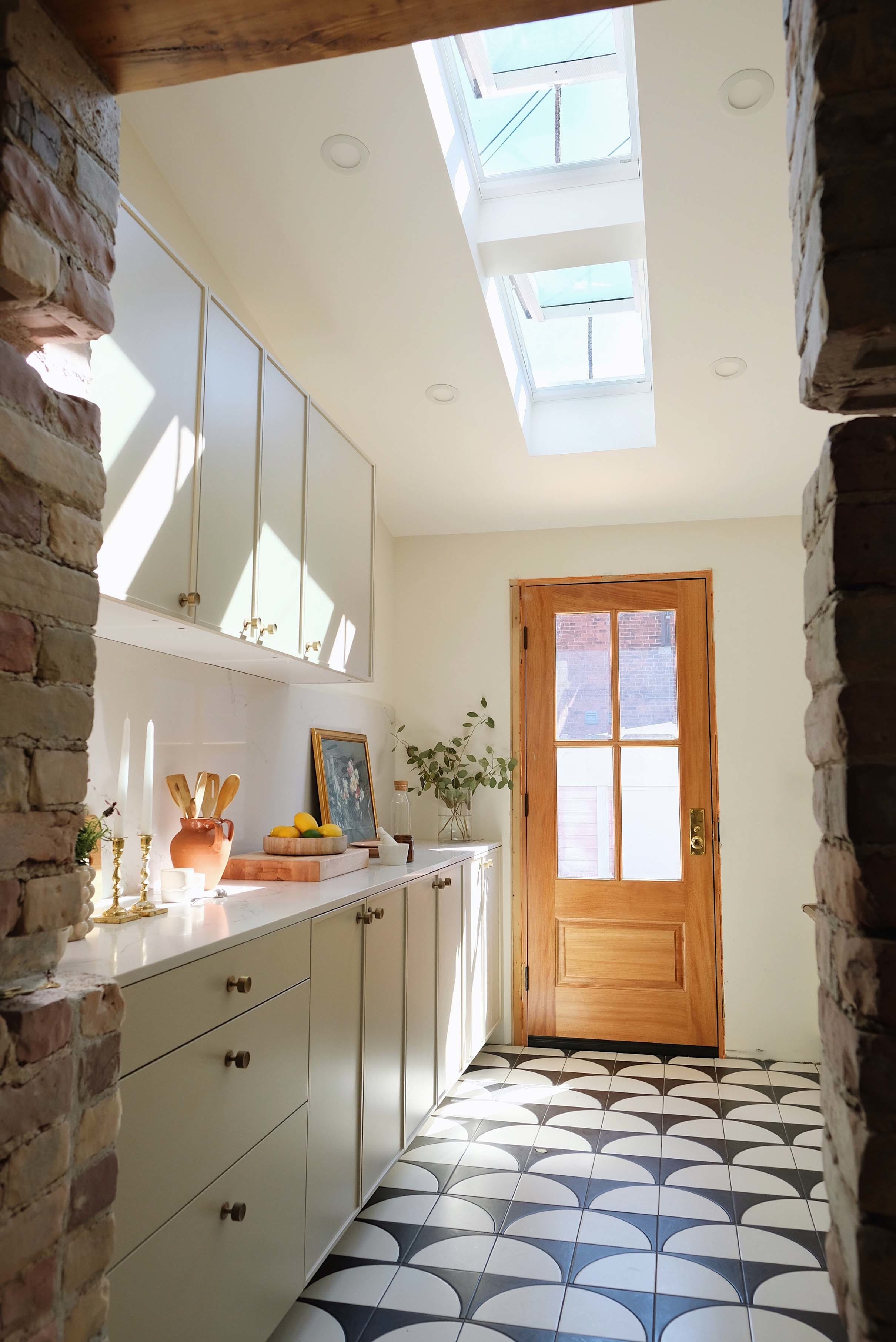 Galley kitchen skylights wood door gray cabinets