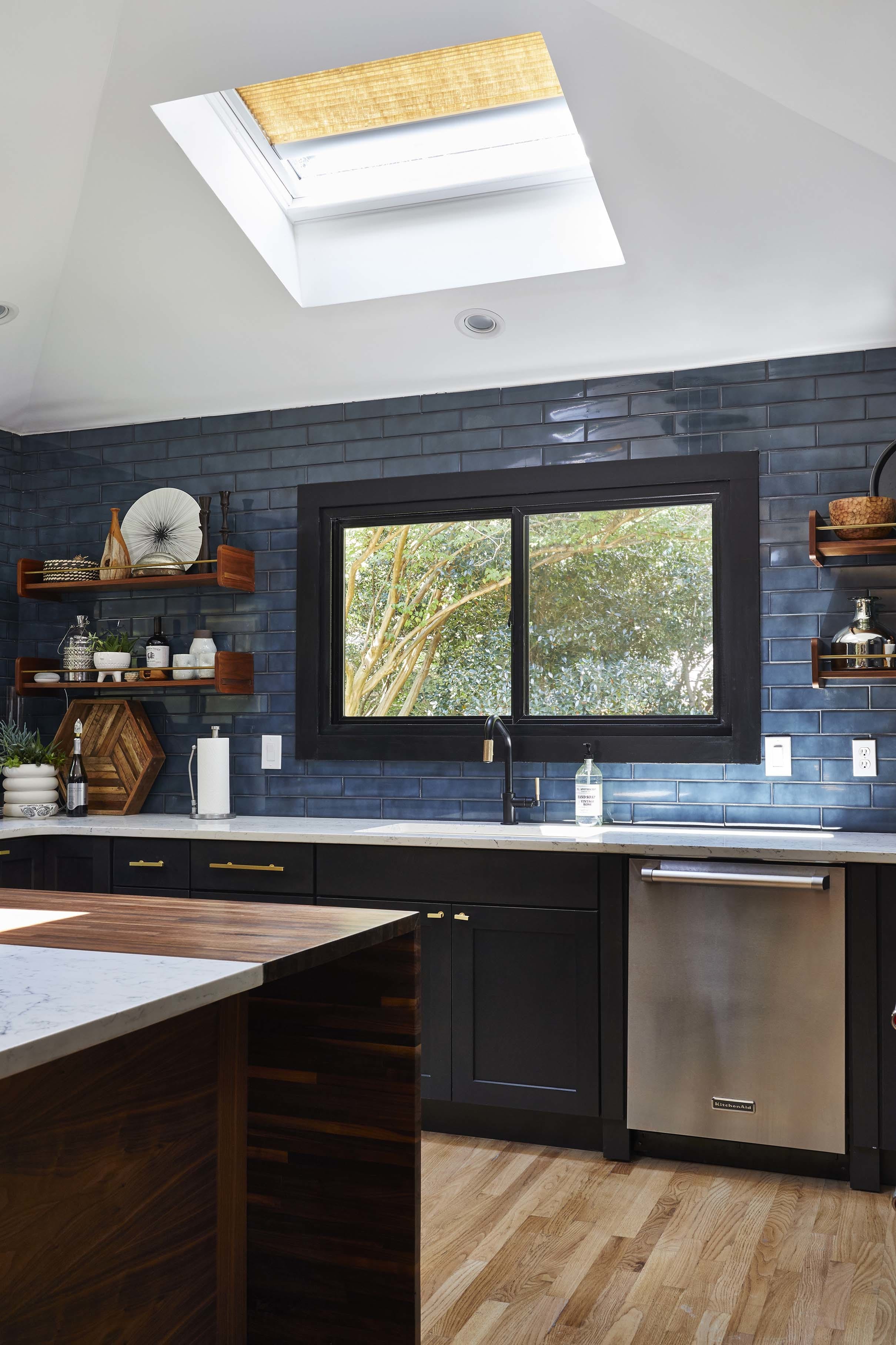 Kitchen black cabinets blue backsplash skylights