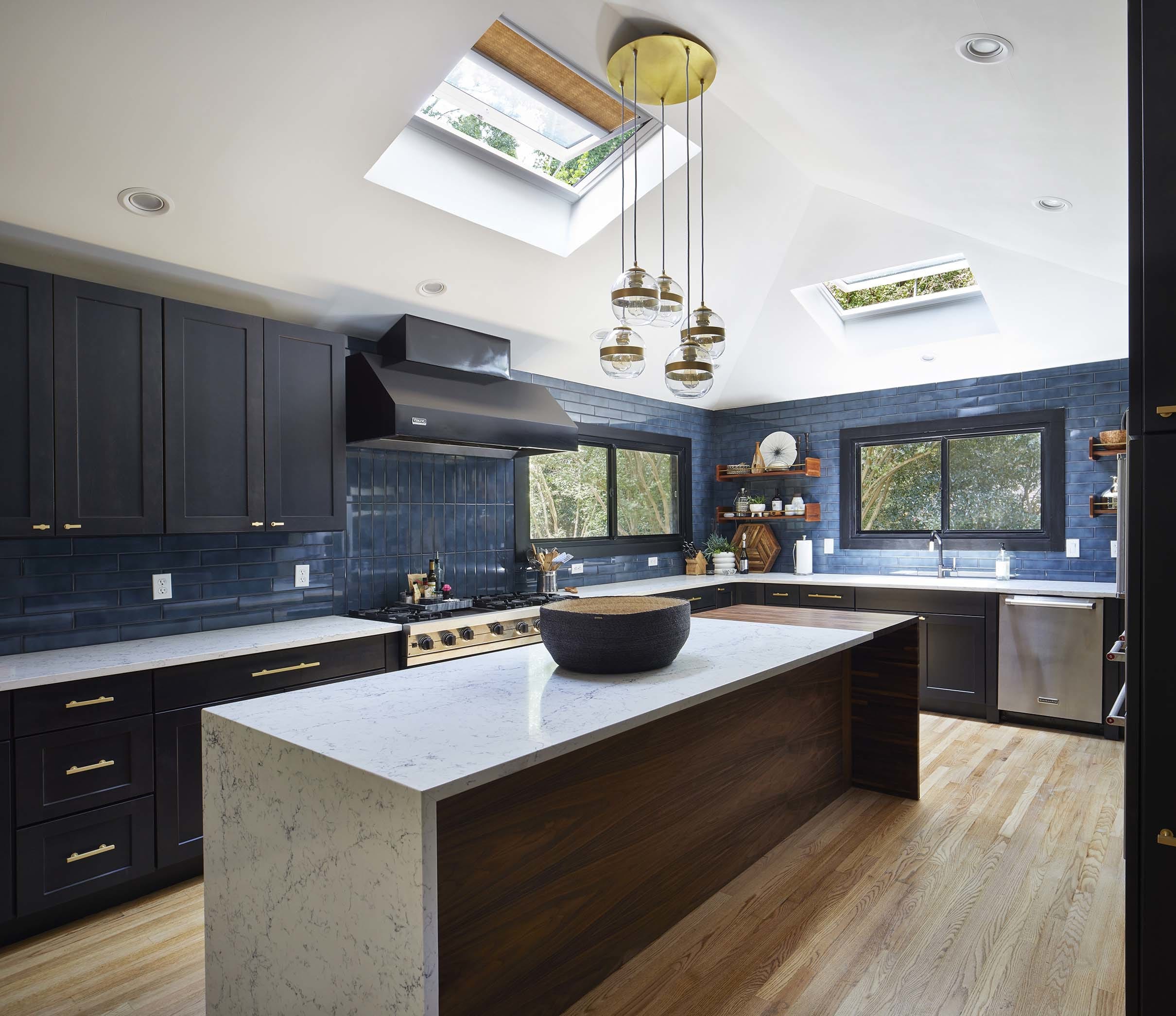 Kitchen two skylights with gold shades black cabinets brass hardware