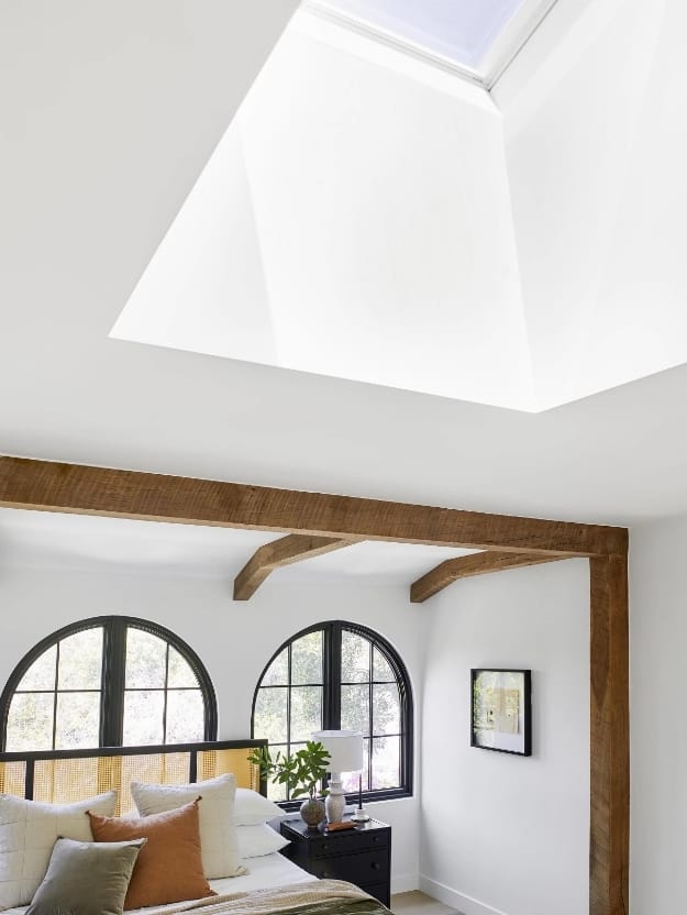 Skylight over bed green rust cream pillows