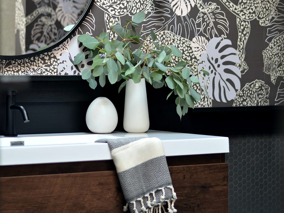 a plant sitting on a wooden vanity with a stone countertop