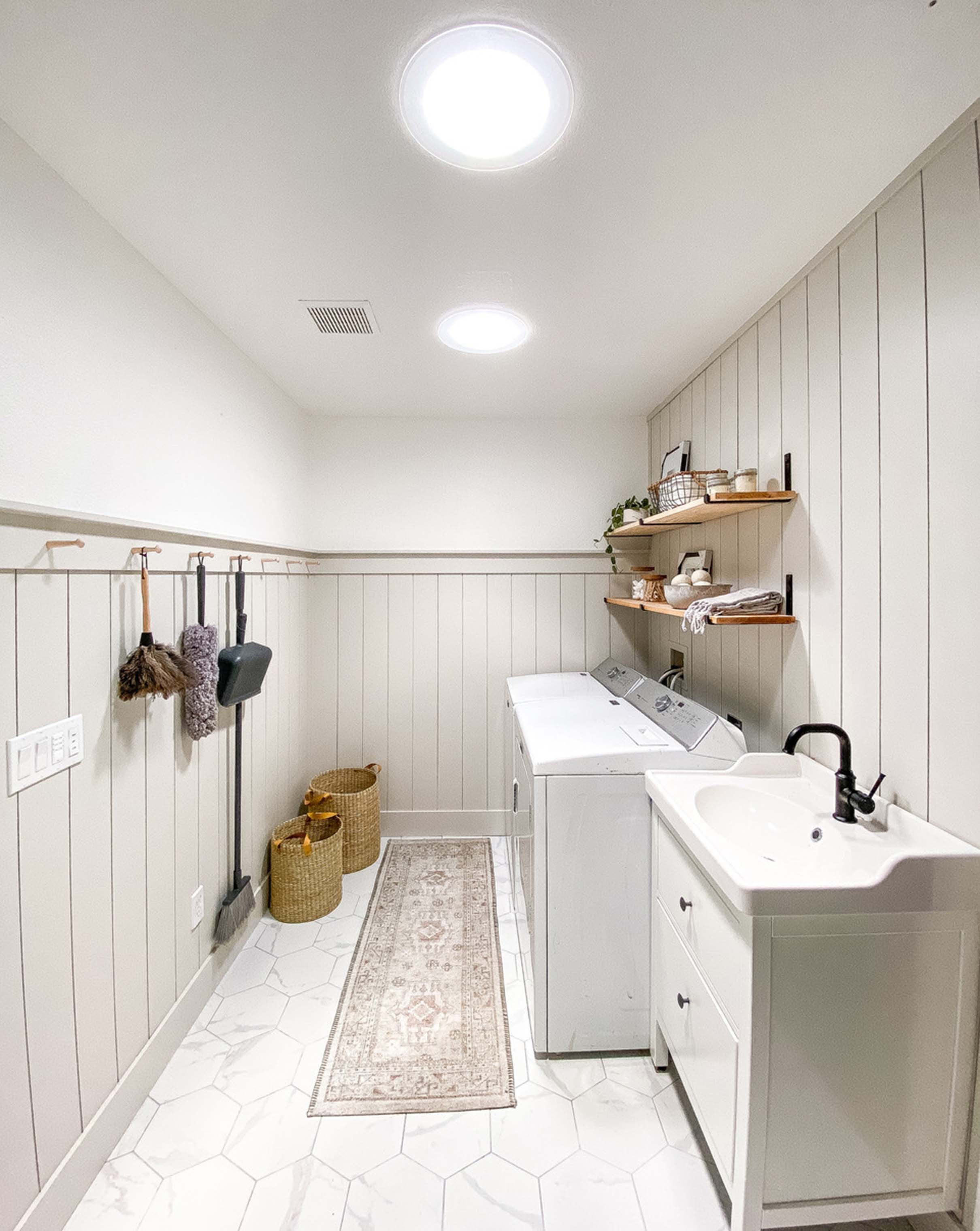 two sun tunnels brighten a white and greige laundry room