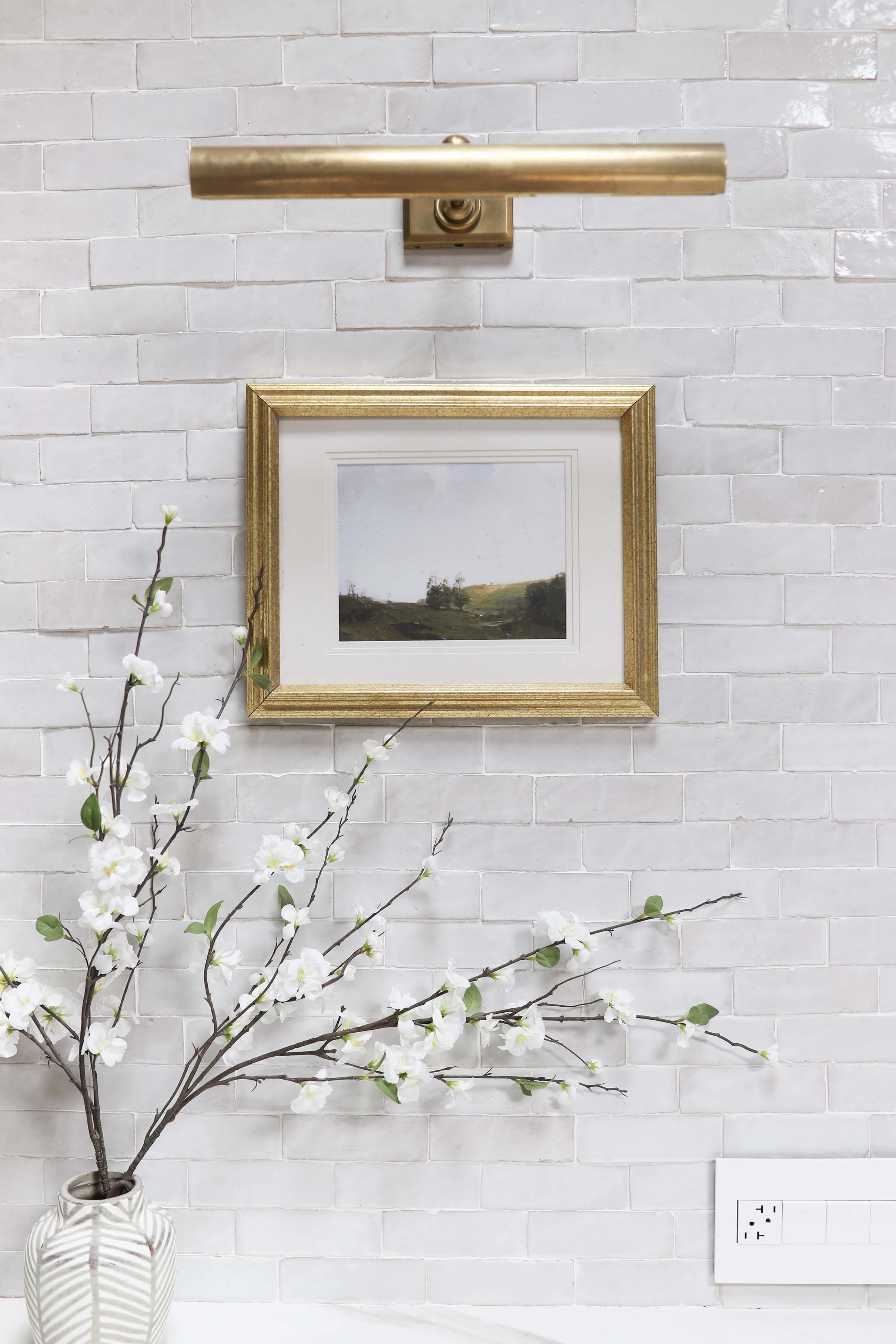 White textured tile backsplash brass light fixture